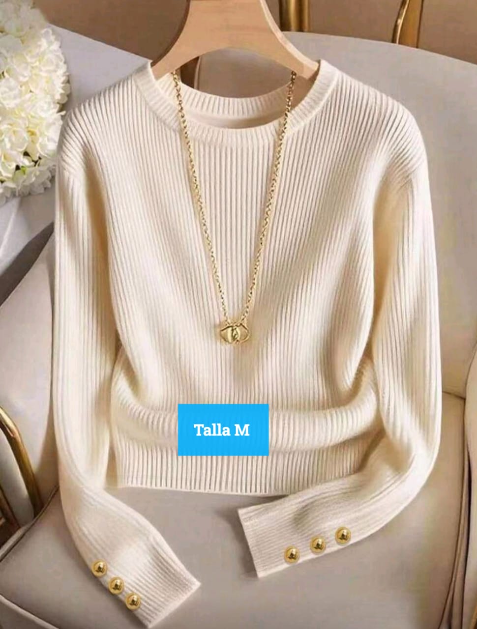 Talla: M  Color: Beige / crema  Material: Tejido acanalado (tipo knit)  Diseño:  Cuello redondo.  Tejido fino y elástico, de corte ajustado.  Manga larga con 3 botones dorados decorativos en cada puño.  Estilo clásico y elegante